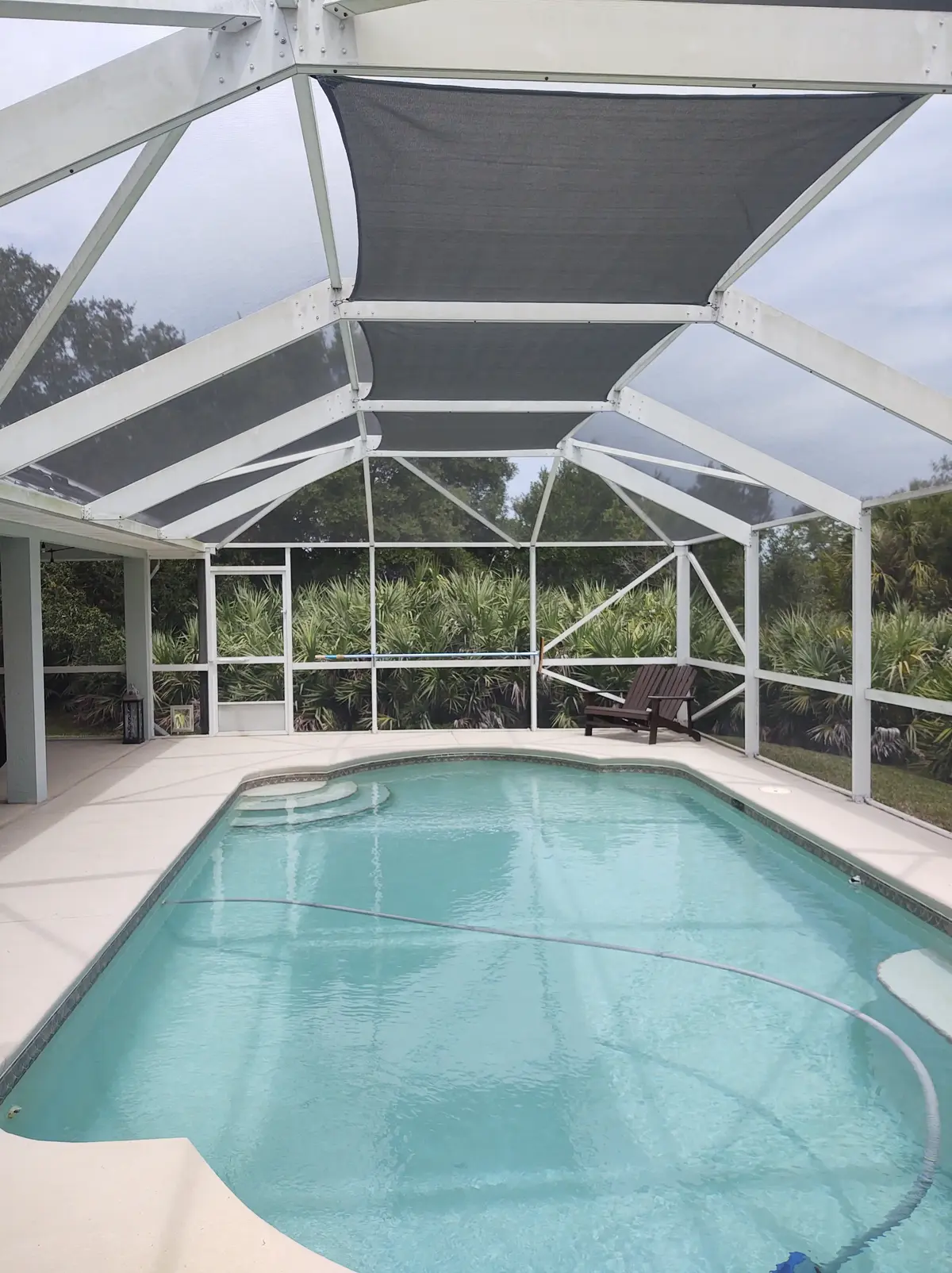 Tan shade sail over pool area